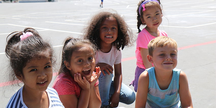 five elementary students smiling