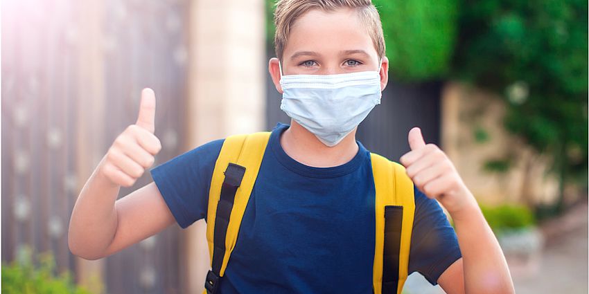 boy wearing mask with thumbs up