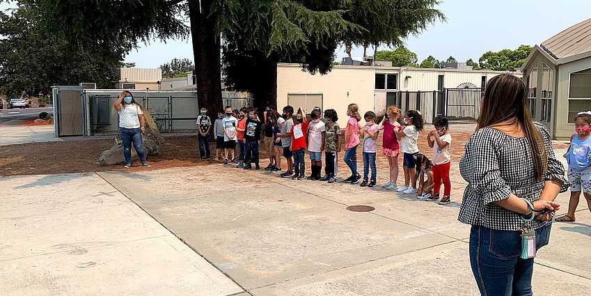 Teachers and students lined up outside of school