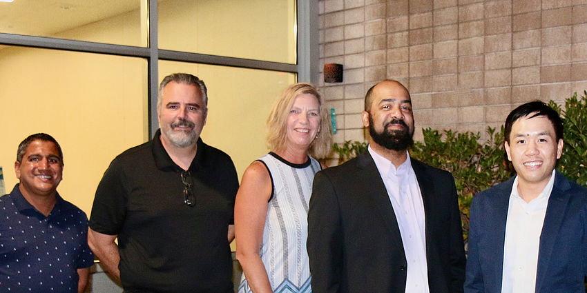 4 men and 1 woman standing together and smiling