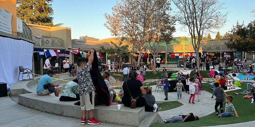 Students and parents gathering at school with flags from different countries.