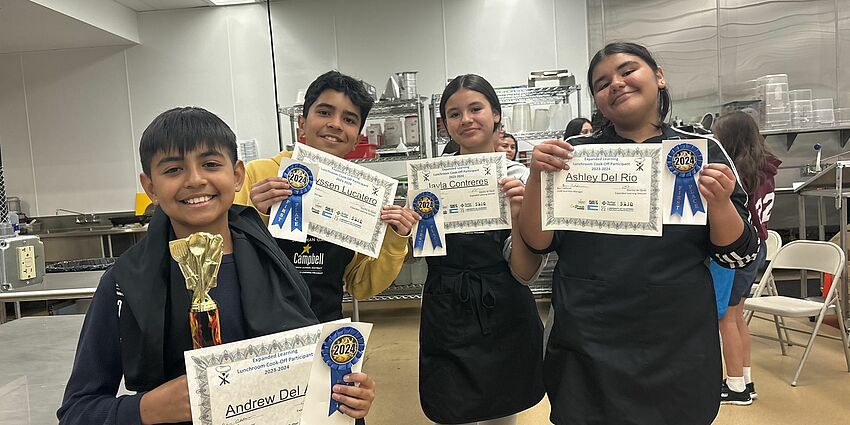 students holding winning certificates