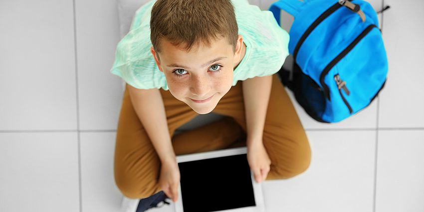 boyon floor with digital tablet smiling