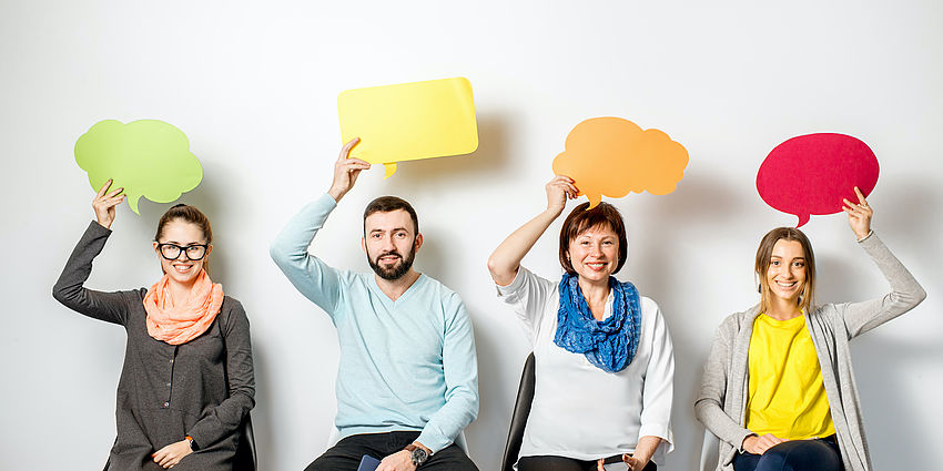 men and women holding thought bubbles over head