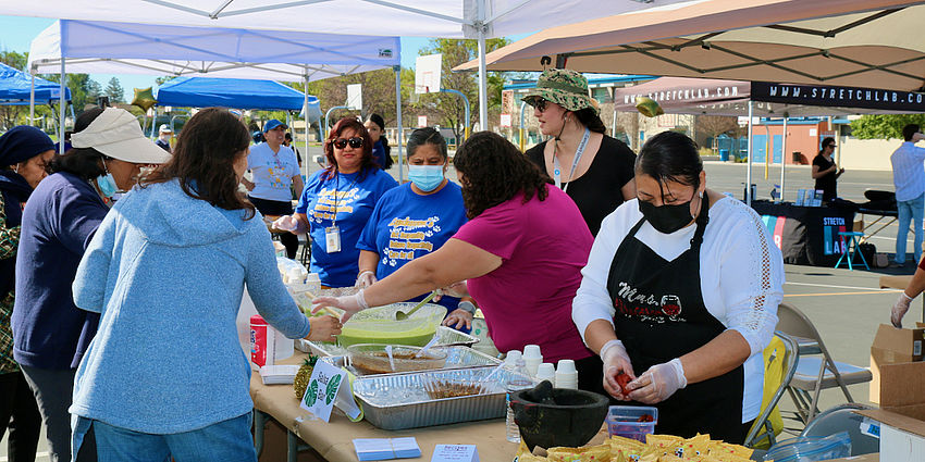 ladies serving fresh food at the wellness fair