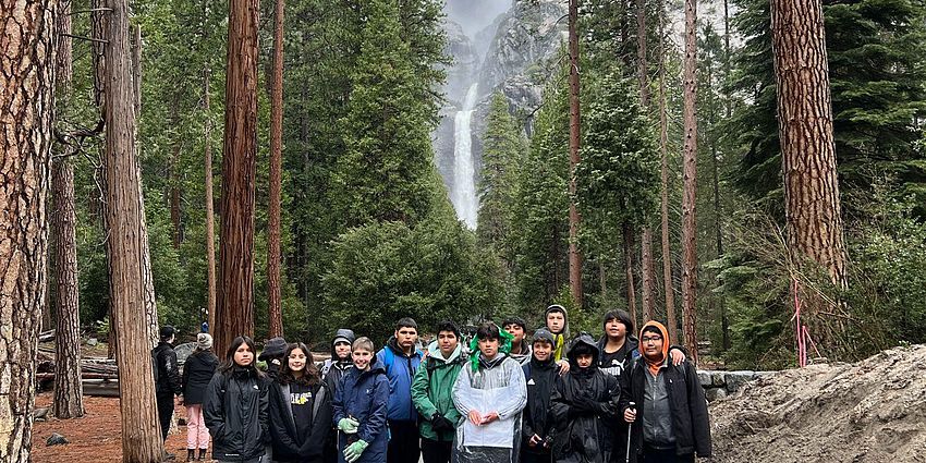students in front of waterfall 