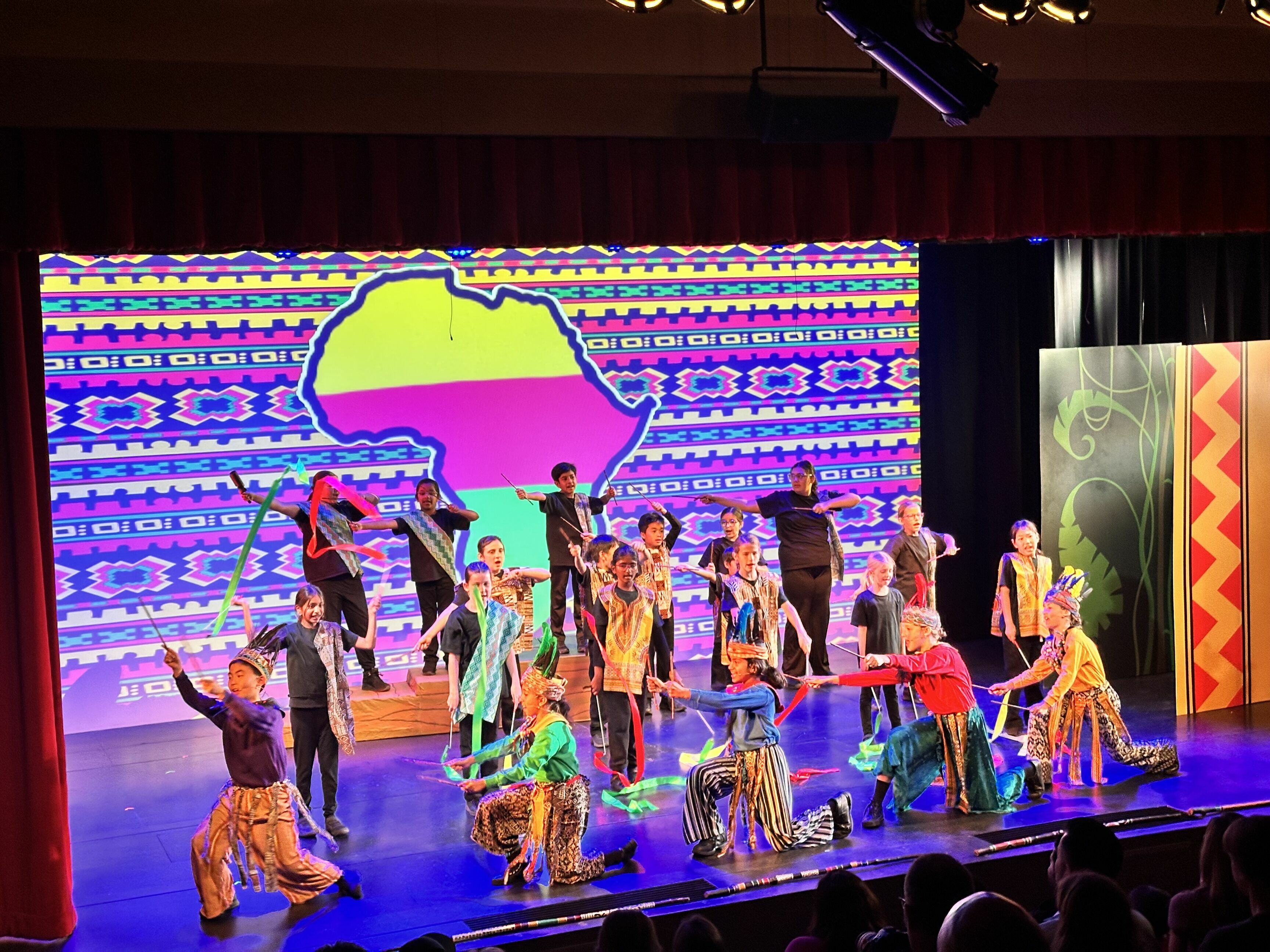 stage full of young students performing Lion King Jr.