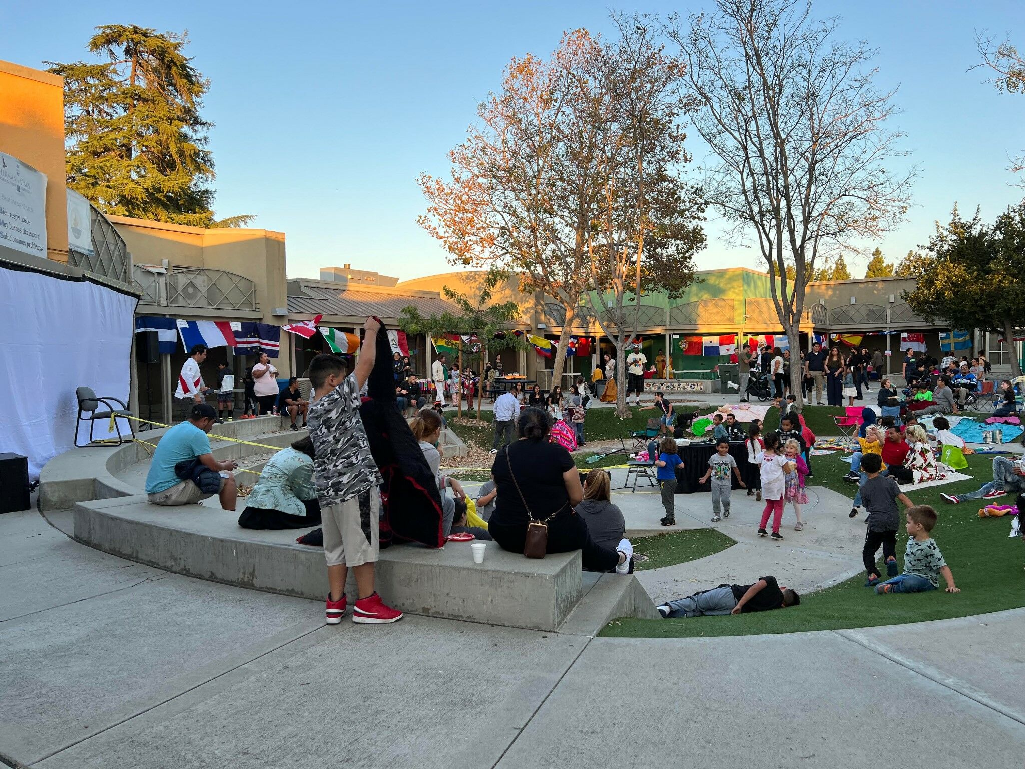 Students and parents gathering at school with flags from different countries.