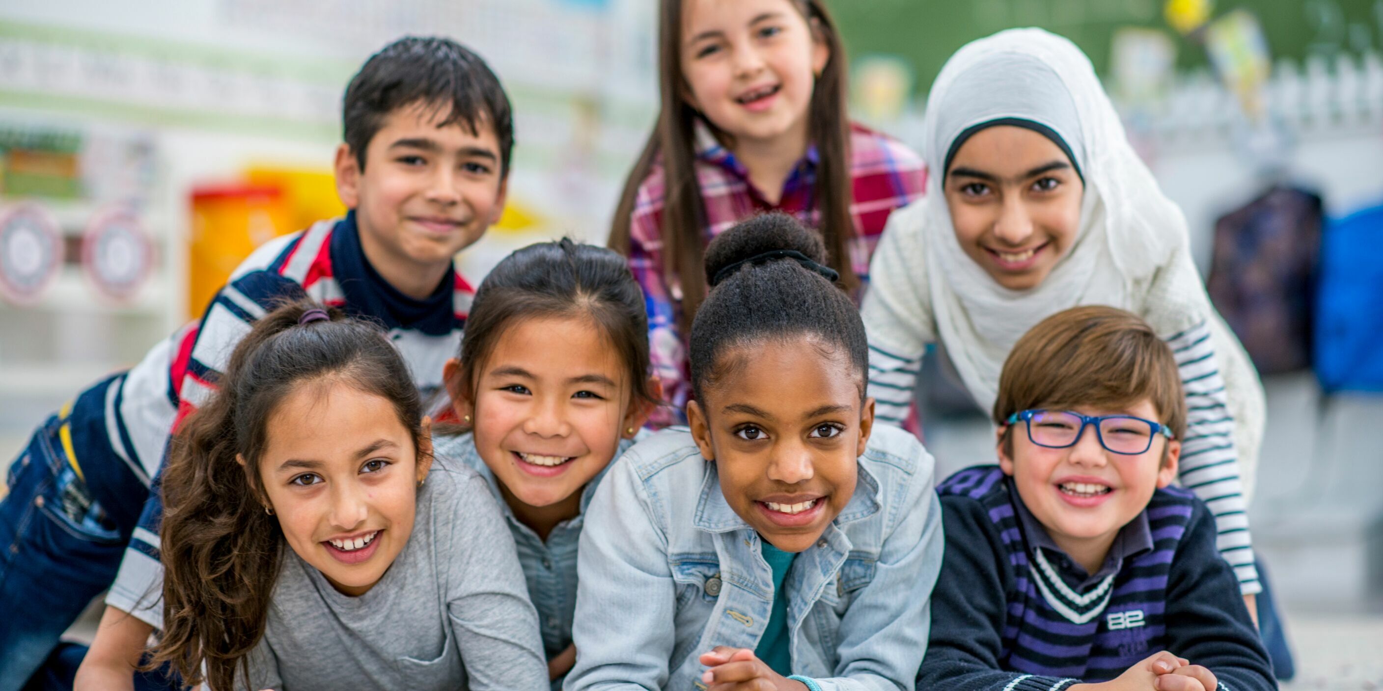 7 children of different ethnicities smiling together in a group