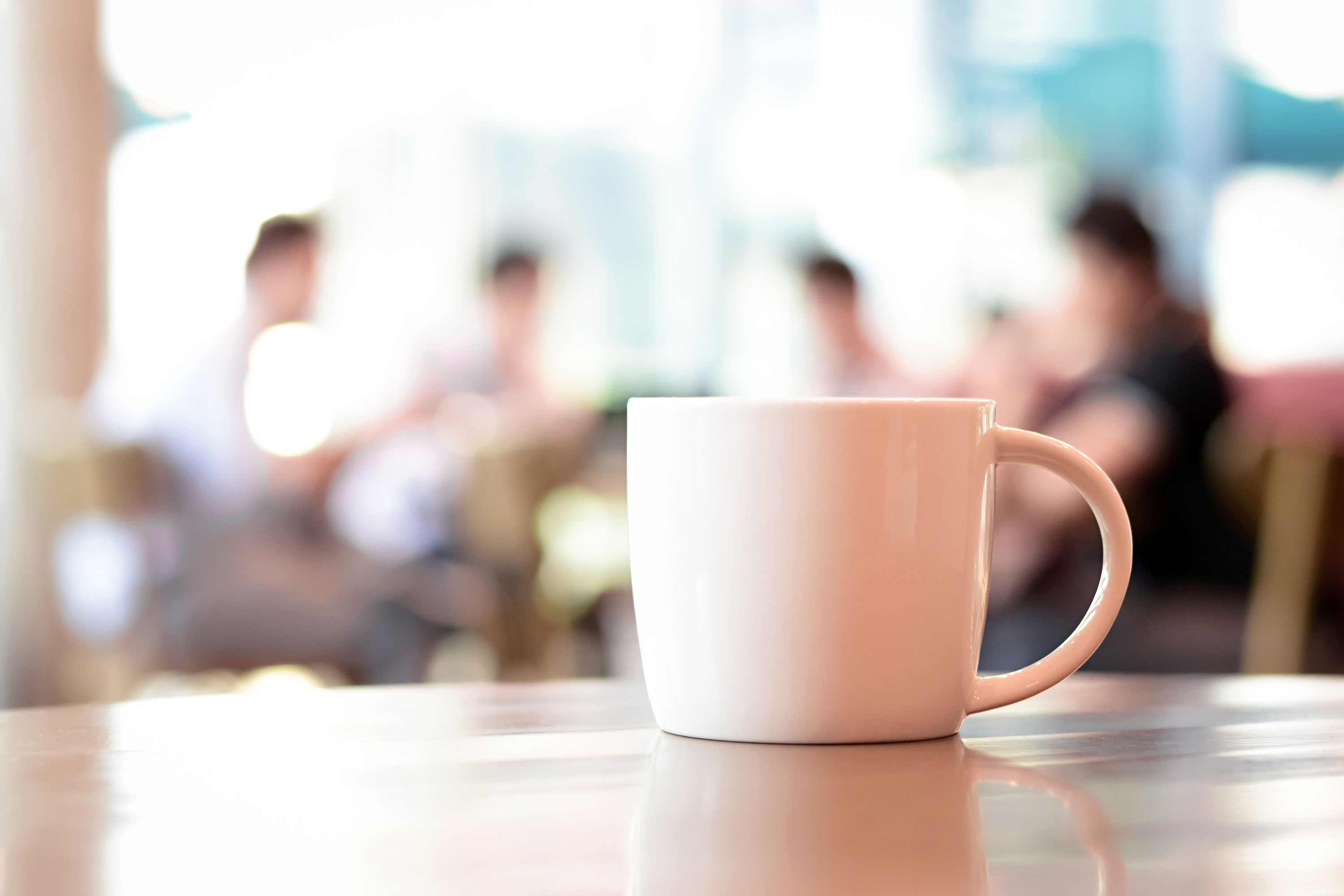 Coffee cup with people meeting in the background