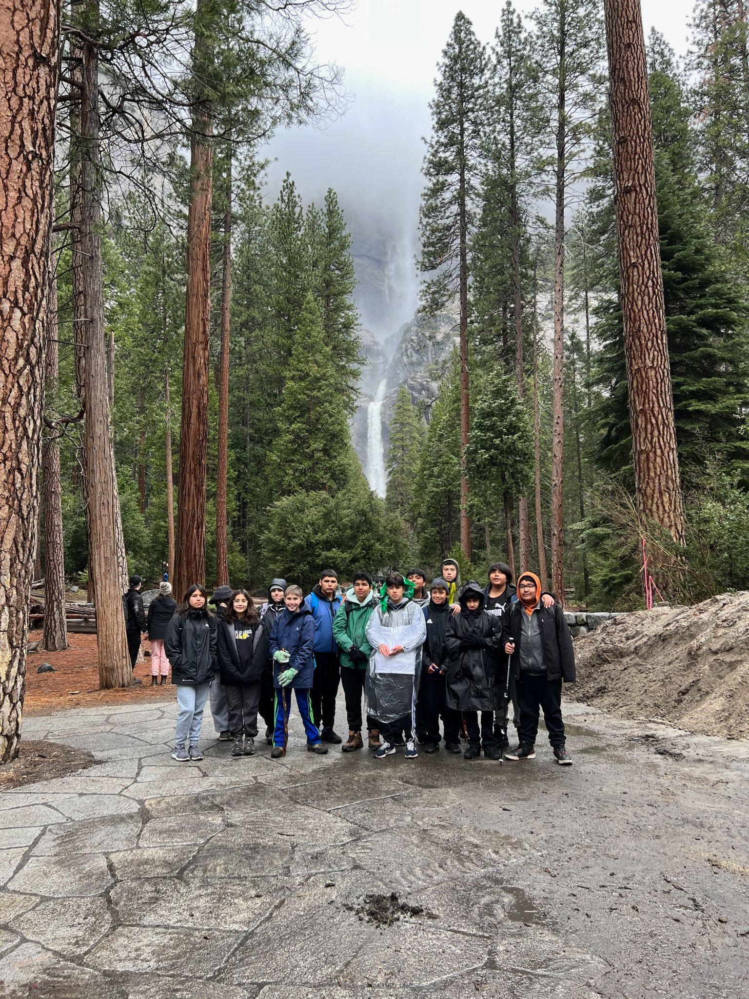 students in front of waterfall 